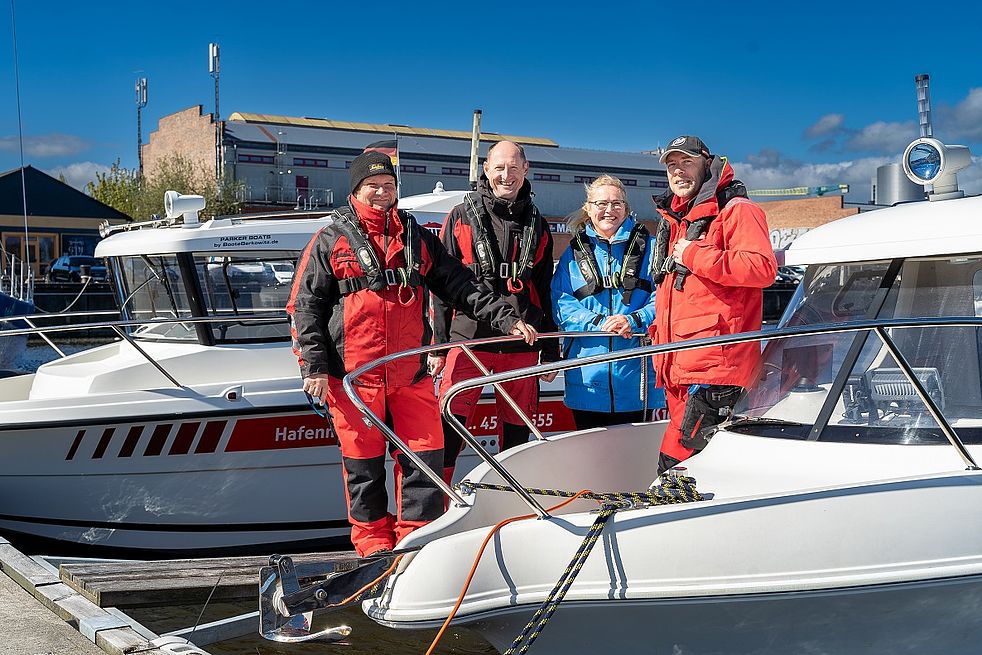 Anke Anderssohn und ihre drei Hafenmeister auf eoinem Boot in einer Reihe.